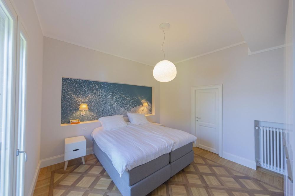 Schlafzimmer mit Wandbild in Seeblau